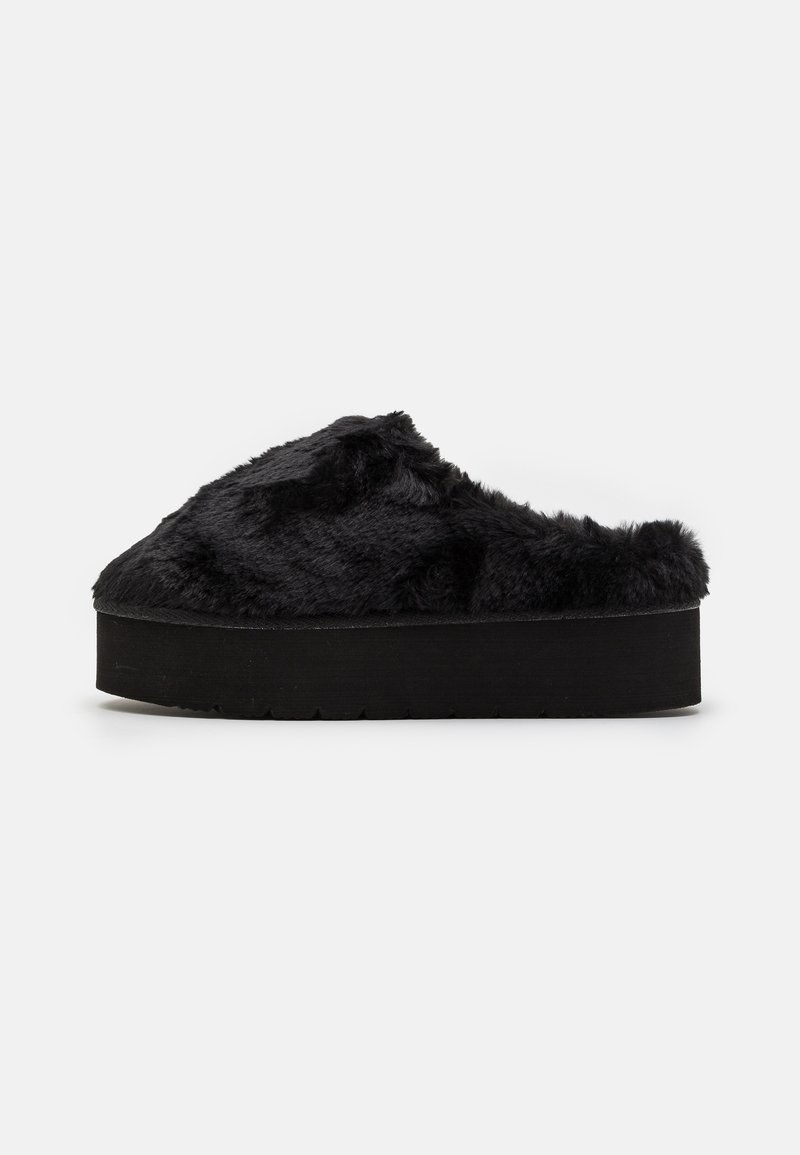Chaussons à enfiler en fausse fourrure noire avec une semelle plateforme noire épaisse ; texture douce et design arrondi, adaptés pour une utilisation en intérieur.