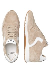 Beige Wildlederschuhe mit weißen Akzenten, Schnürdesign, gepolsterter Zunge und strukturiertem Gummisohle; abgerundete Zehenpartie und genähte Details.