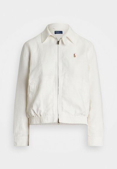 Casaco de linho branco com gola, fecho frontal em zip, cintura elástica e um pequeno logótipo bordado no bolso esquerdo do peito.