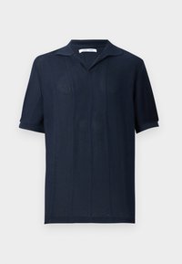 Polo en maille bleu marine foncé à manches courtes avec un motif vertical subtil et un col rabattable sur un fond clair uni.