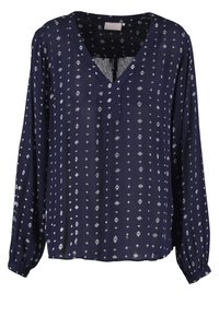 Marineblå, langærmet bluse i let stof med V-hals. Har hvide geometriske mønstre over det hele og indsamlede manchetter.