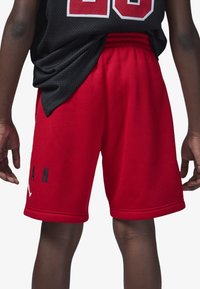 Pantalones cortos rojos hechos de tela suave, con una cintura elástica y detalles de texto en negro. Diseño sencillo con un corte clásico, ideal para deportes.