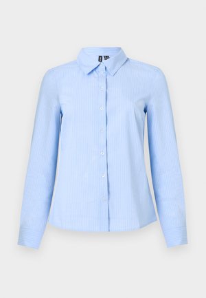 Gaiši zils krekls ar gariem piedurknēm, pogājamu priekšpusi, apkakli un vertikālām baltām svītrām. Izgatavots no gludas auduma ar pieguļošu formu.