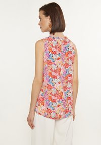 Top senza maniche con un motivo floreale dai colori vivaci, caratterizzato da un dettaglio a chiave sul retro e una vestibilità rilassata. Realizzato in un tessuto leggero.
