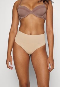 Reggiseno in marrone chiaro con pizzo; culotte beige a vita alta. Entrambi presentano una texture liscia e un design senza cuciture per il massimo comfort.