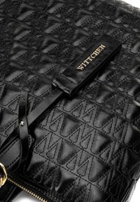 Czarna skórzana torba o teksturowanym wzorze, z złotym logo "WITTCHEN" i zapięciem na zamek. Zawiera czarny pasek.