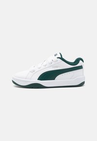 Baskets blanches avec une bande latérale en cuir vert, tige texturée, semelle en caoutchouc lisse et lacets ronds. Logo PUMA sur le côté et sur la languette.