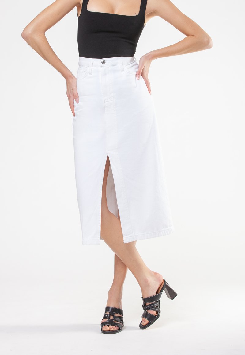 Hvid denim midi-nederdel med slids foran, høj talje og fem-lomme design, parret med sorte blokhæle sandaler.