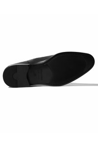Suela de zapato de cuero negro con agarre de goma texturizado, con forma redondeada y superficie lisa. Logo grabado y tamaño visibles.