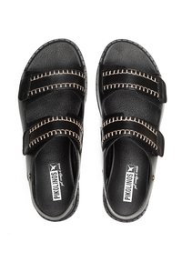 Sandalias de cuero negro con tres correas ajustables, que presentan costuras en contraste y suelas texturizadas para un mejor agarre. Logotipo de la marca visible en el interior.