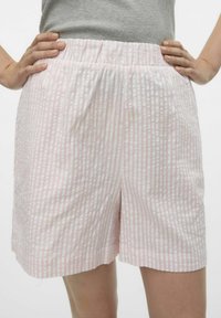 Roze en witte gestreepte shorts met een elastische tailleband, voorzien van een comfortabele pasvorm en zijzakken, gemaakt van lichte stof.