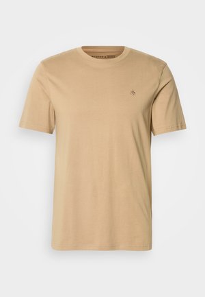 Beige cotton t-shirt with a round neckline, short sleeves, and a small embroidered logo on the chest. Smooth texture and standard fit.