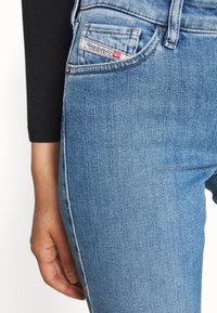 Blå denimjeans med medel tvätt, med en klassisk fickdesign och en liten logotag på den främre fickan.