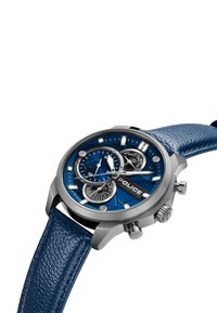 Zils ādas siksniņas pulkstenis ar apaļu sudraba nerūsējošā tērauda korpusu, teksturētu zilu ciparnīcu un trim subciparnīcām. Tajā ir redzams "POLICE" zīmols.