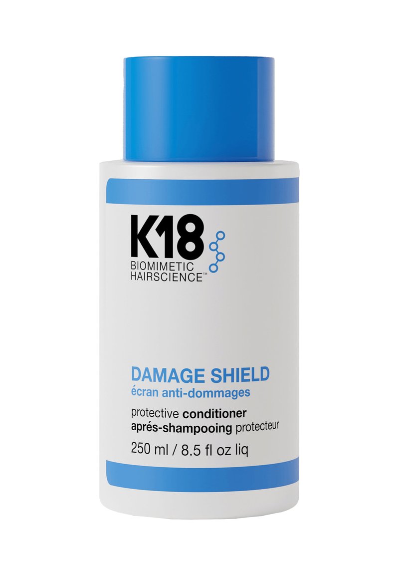 Witte fles met een blauwe dop en accenten. Etiket bevat "K18," "Damage Shield," en productdetails in het Engels en het Frans. 250 ml.