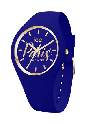 Montre en silicone bleue avec un cadran rond, des marqueurs et aiguilles dorés, ainsi que le texte "Paris" en script. Caractéristiques d'un bracelet à boucle.