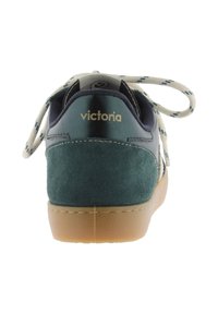 Sneaker in suede verde e pelle blu navy con suola in gomma color miele e lacci crema. Presenta un piccolo logo dorato sul retro.