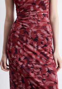 Rotes Blumenkleid mit einer figurbetonten Silhouette, ausgestattet mit einem glatten, elastischen Stoff und einem Muster aus sanften rosa und dunklen Blumen.