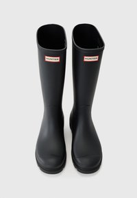 Black rubber rain boots with a smooth texture, rectangular openings at the top, and red-and-white "HUNTER" logos on each side.