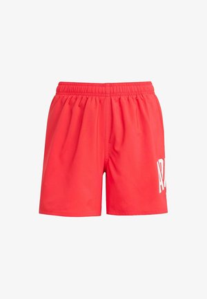 Pantaloni sportivi rossi con cintura elastica, texture liscia e un logo bianco sul lato sinistro. Caratterizzati da un design morbido.