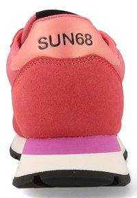 Scarpa sportiva di colore corallo con tomaia in suede, accenti neri e una suola intermedia bianca con una striscia viola; nome del marchio "SUN68" sul tallone.