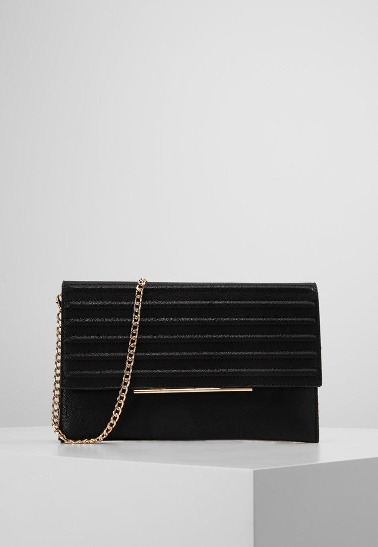 Svart kuvertväska med horisontella veck, guldig kedjehandtag som hänger över framsidan, och en tunn guldaccentstång på framsidan, på vit yta.