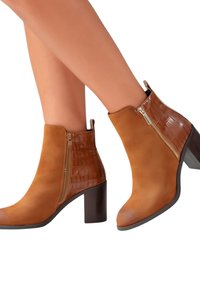 Bottines à talons brunes avec un corps en daim lisse et des accents en croco brillant, dotées de fermetures éclairs sur les côtés et d'un design à bout arrondi.