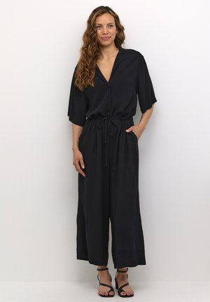 Black jumpsuit with a button-up front, short sleeves, and an adjustable drawstring waist; lightweight fabric and wide legs.