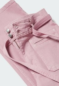 Różowe dżinsy z zamkiem błyskawicznym, dwoma srebrnymi guzikami oraz boczną kieszenią z detalami w szwie. Materiał jest gładki z lekko teksturowanym wykończeniem.