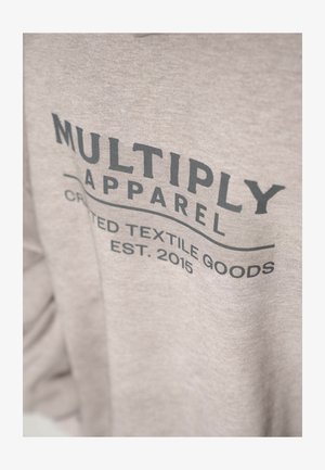 Felpa grigia realizzata in tessuto morbido; presenta un audace testo nero "MULTIPLY APPAREL" e "CRAFTED TEXTILE GOODS EST. 2015" in design grafico.