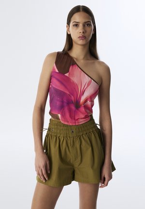 Haut asymétrique à une épaule en imprimé floral rose vif avec accent brun, associé à un short ample vert olive doté d'une taille élastique.