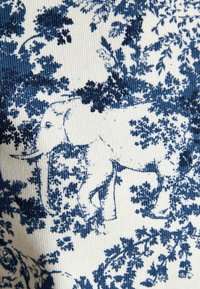 Kangas, millel on sinise ja valge lilleline muster, sisaldades peeneid elevandimotiive, tekstuuriga pind ja ribatud disain.