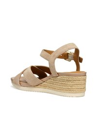 Sandalo a zeppa in suede beige con cinturini incrociati e tacco in juta intrecciata. Presenta una soletta imbottita e una cintura alla caviglia regolabile.