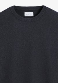 Suéter de un oscuro azul marino hecho de material suave. Presenta un cuello redondo clásico, puños acanalados y un sutil detalle del logo en el pecho.