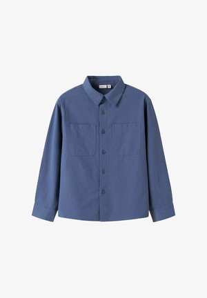 Camisa azul de manga larga con botones y dos bolsillos en el pecho, y cuello puntiagudo, mostrada sobre un fondo blanco.