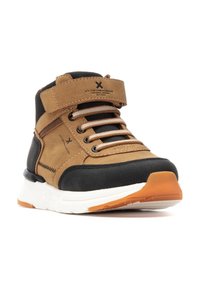 Zapatillas de media caña en marrón y negro, fabricadas con materiales de serraje y sintéticos, que cuentan con una correa de gancho y bucle, cierre de cordones y suela de goma.