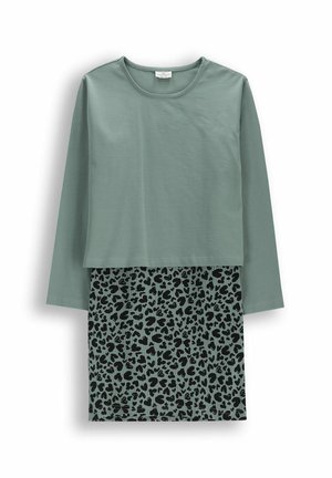 Zielona bluzka z długim rękawem i okrągłym dekoltem, noszona na plisowanej spódnicy w tym samym odcieniu zieleni z czarnym wzorem w cętki lamparta.