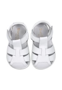 Sandalias de cuero blanco con diseño recortado, correa ajustable y suela texturizada. Logo de marca notable en la plantilla.