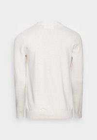 Ljusbeige långärmad tröja med rund hals, tillverkad av mjukt material. Har ribbade ärmslut och nederkant, slät textur och inga synliga mönster.