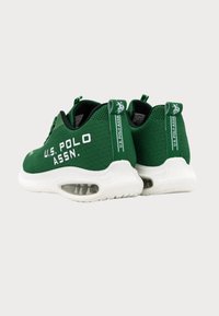 Zöld hálós sportcipők fehér középtalpakkal, oldalán és hátulján a "U.S. POLO ASSN." felirattal, valamint párnázott légpárnával a sarokban.