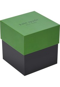 Caja de regalo cuadrada con tapa verde y base negra. La tapa presenta el texto "kate spade" en letras oscuras, hecho de un acabado de papel mate.