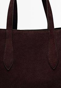 Ciemno-bordowa torebka z zamszu, o textured powierzchni, z dwoma wydłużonymi uchwytami i kontrastującymi przeszyciami. Minimalistyczny design. Bez elementów metalowych.