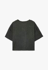 Top de color gris oscuro de manga corta con un corte holgado, escote redondo y textura de tela suave. Se aprecian detalles de costura a lo largo de los hombros y los lados.