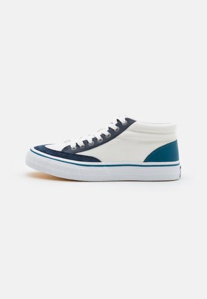 Hvid og marineblå midt-høj sneaker med turkis hæl, hvide snørebånd og en hvid sål med en turkis stribe, vist fra siden.