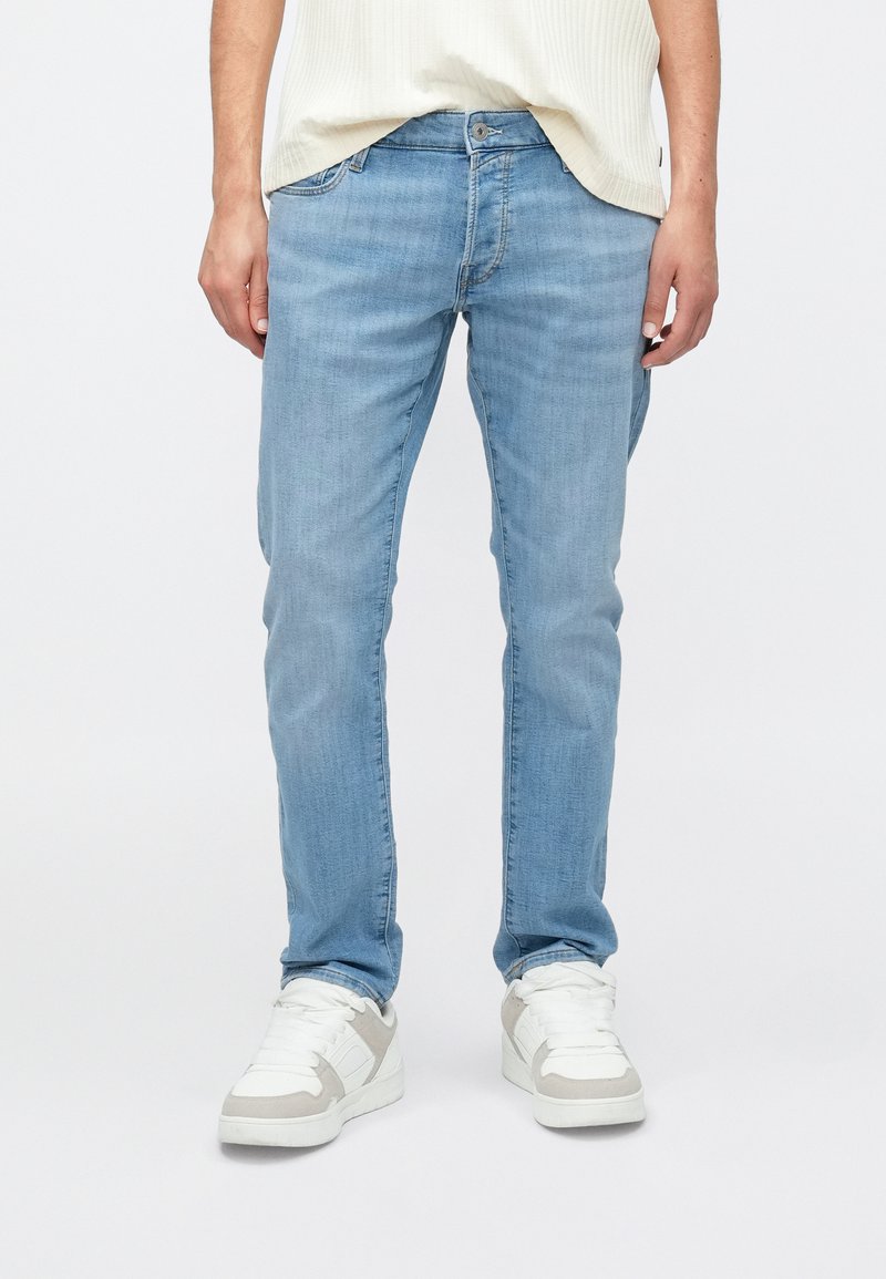 Hele sinised denimist teksad, õhuke lõige, viis taskut ning kerge pleekimine. Kandmisega valgete tossudega, millel on hallid detailid.