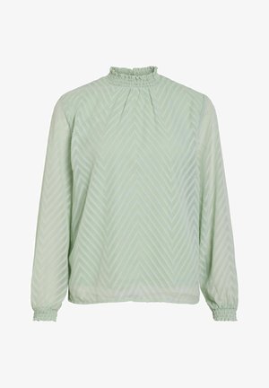 Blusa verde chiaro con maniche lunghe, scollatura arricciata e texture a zigzag. Realizzata in tessuto fluido con polsini arricciati.