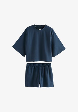 Mornarsko modri dvodelni lounge set, ki vključuje teksturirano kratko majico s kratkimi rokavi in usklajene kratke hlače z elastiko v pasu.