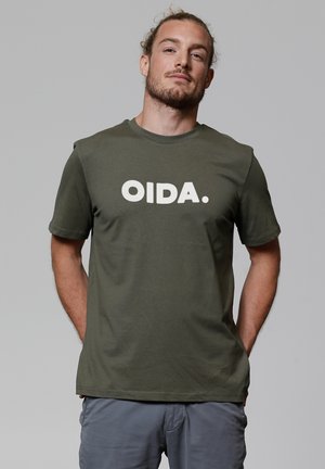 Olijfgroene t-shirt van katoen met korte mouwen, voorzien van vetgedrukte witte tekst "OIDA." op de voorkant. Zachte textuur, ontspannen pasvorm.