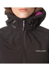Schwarze Softshell-Jacke von Craghoppers mit sicherem Reißverschluss vorne, verstellbarem Kordelzug an der Kapuze und lila Fleece-Futter.