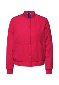 Veste bomber rouge avec un col rond, fermeture à pression, deux poches latérales et des poignets et un ourlet côtelés. Tissu lisse et léger.